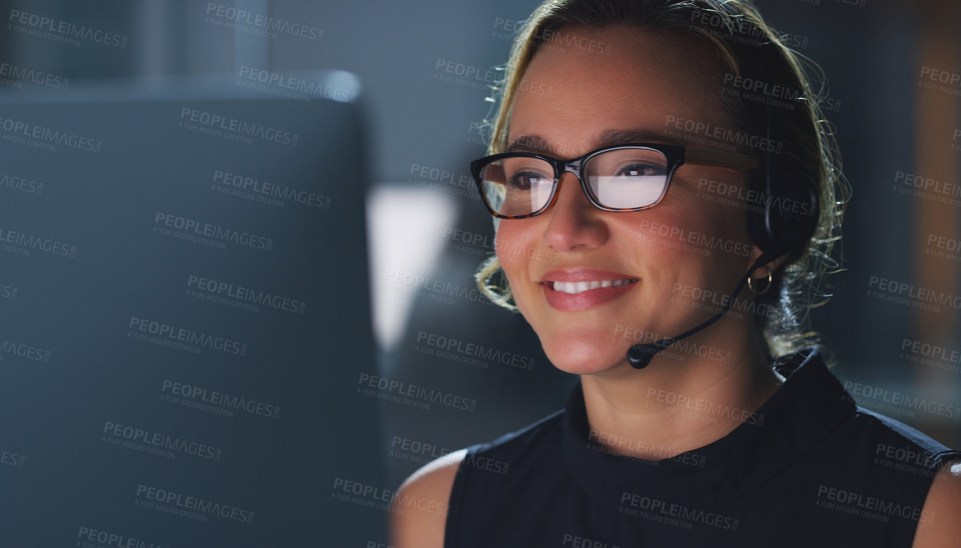 Buy stock photo Cropped shot of an attractive young female call center agent working late at night in the office