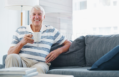 Buy stock photo Shot of a senior man relaxing with a cup of coffee on the sofa at home