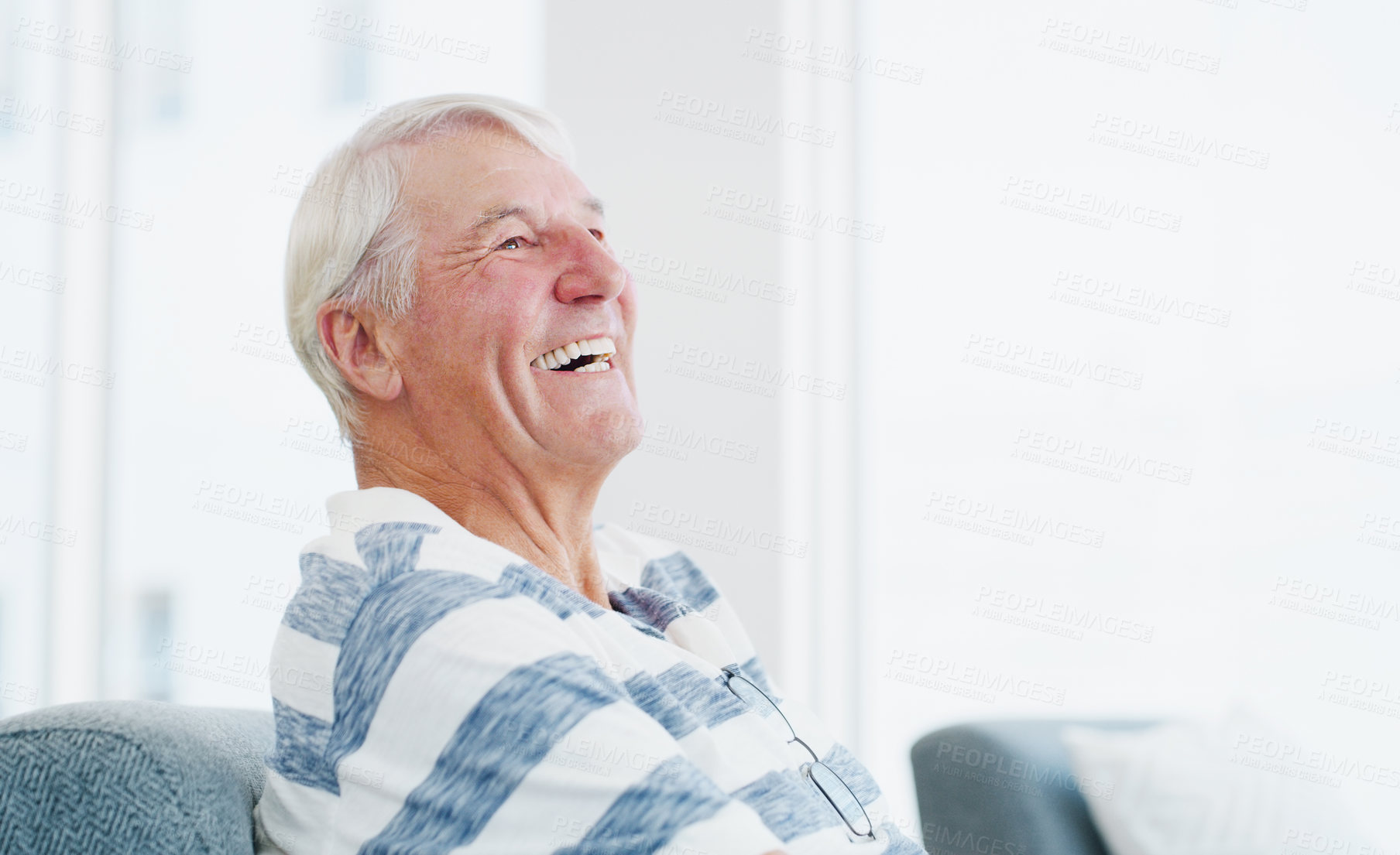 Buy stock photo Break, funny and thinking with old man on sofa in home living room for me time, retirement or wellness. Ideas, reflection and relax with happy senior laughing in apartment for memory or satisfaction