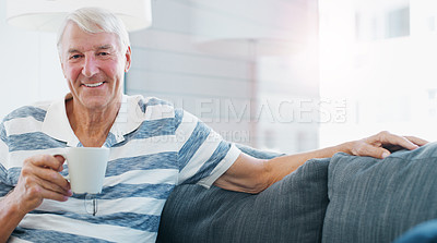 Buy stock photo Shot of a senior man relaxing with a cup of coffee on the sofa at home