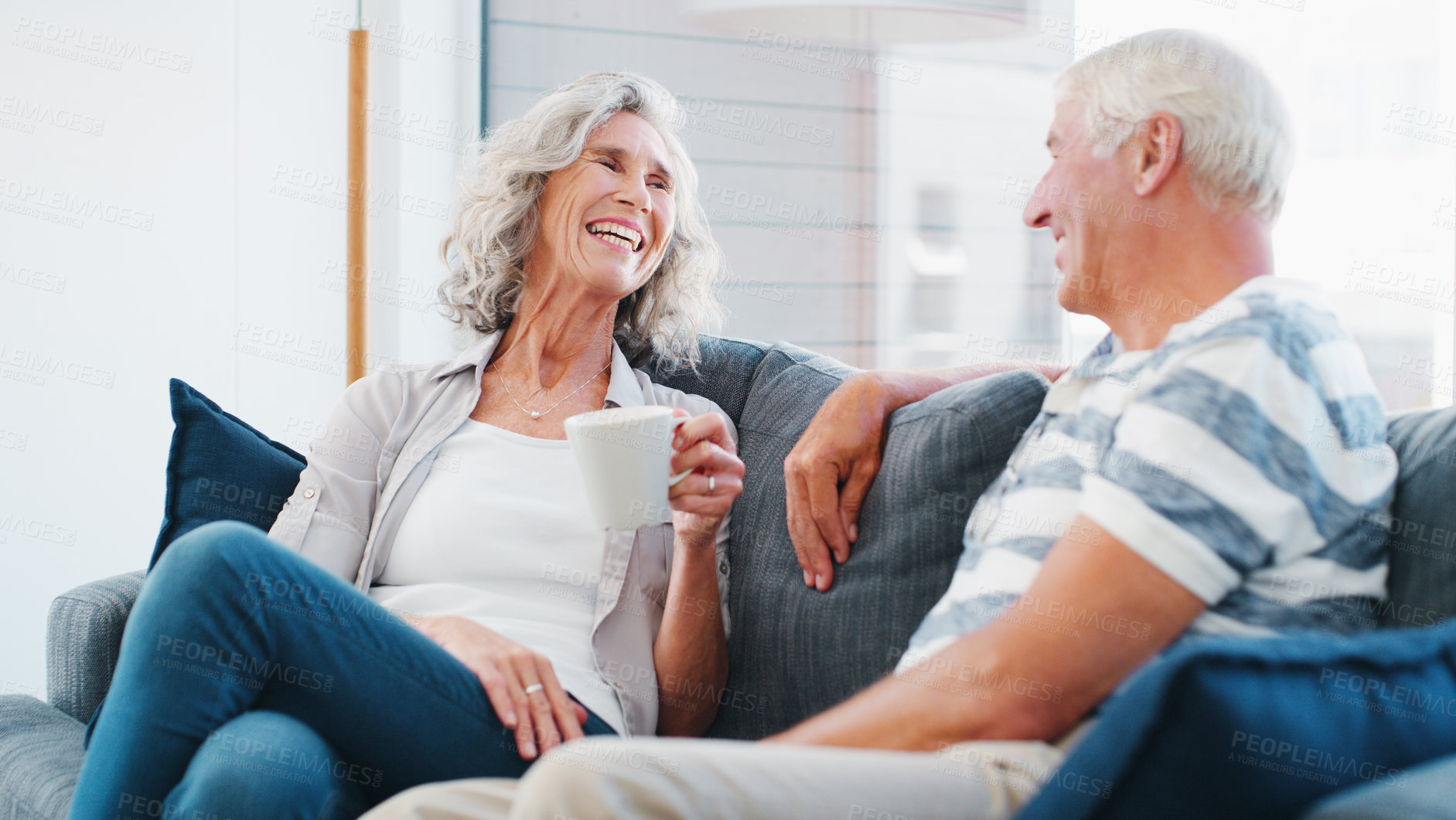 Buy stock photo Mature couple, home and laughing with coffee on sofa in living room on break, bonding and relax. People, relationship and happy for love with cup for conversation, chat and funny memories on couch