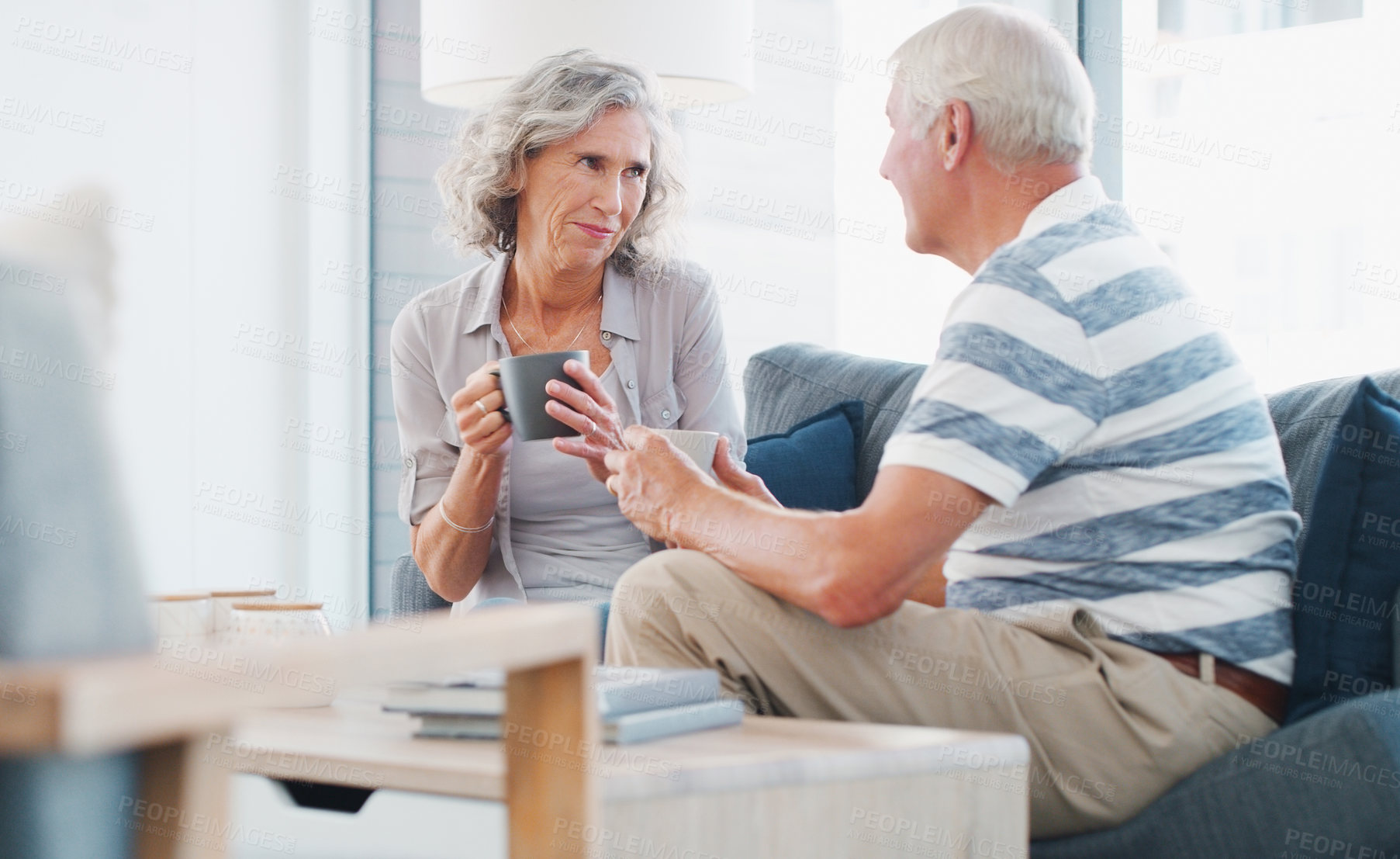 Buy stock photo Mature couple, home and happy with tea on sofa in living room on break, bonding and relax. People, relationship and smile for love with cup for conversation, chat and care for memories on couch