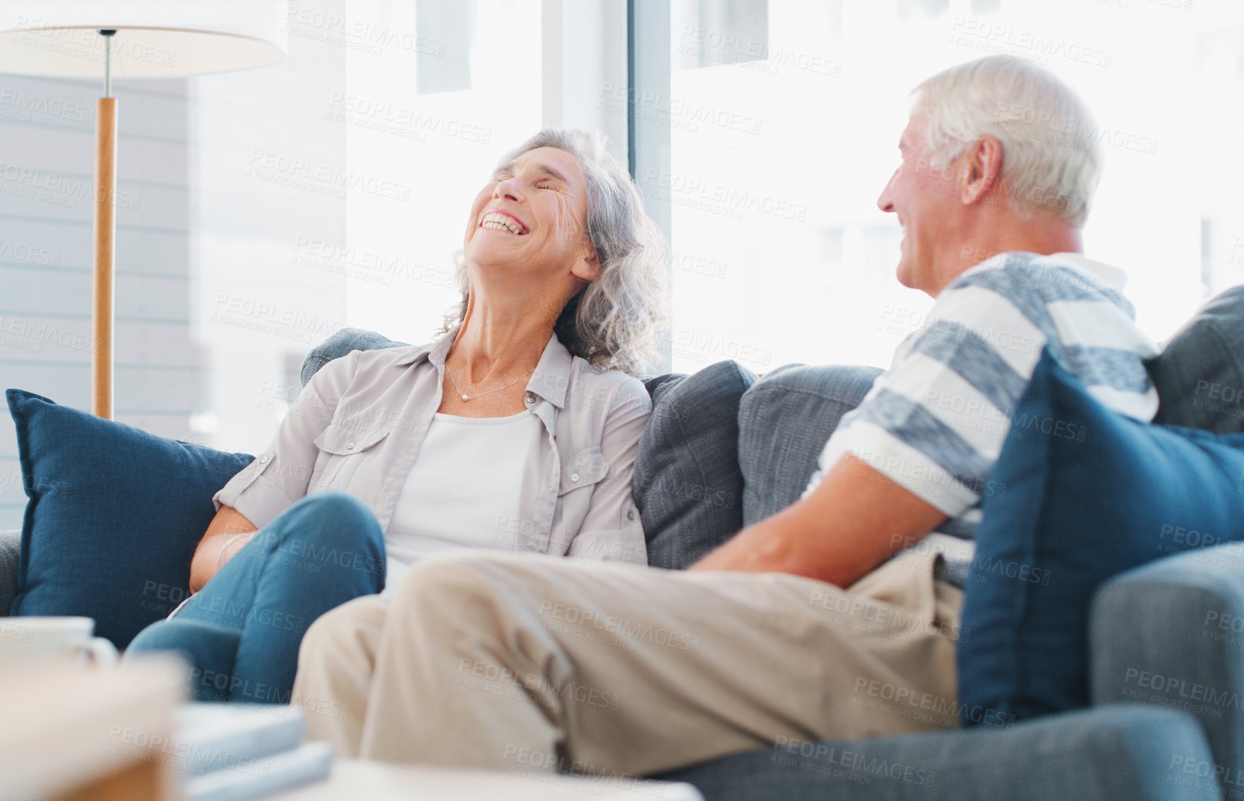 Buy stock photo Senior couple, home and laugh on couch in living room on break, bonding and relax. People, relationship and smile or happy on retirement for conversation, chat and funny memories on sofa for care