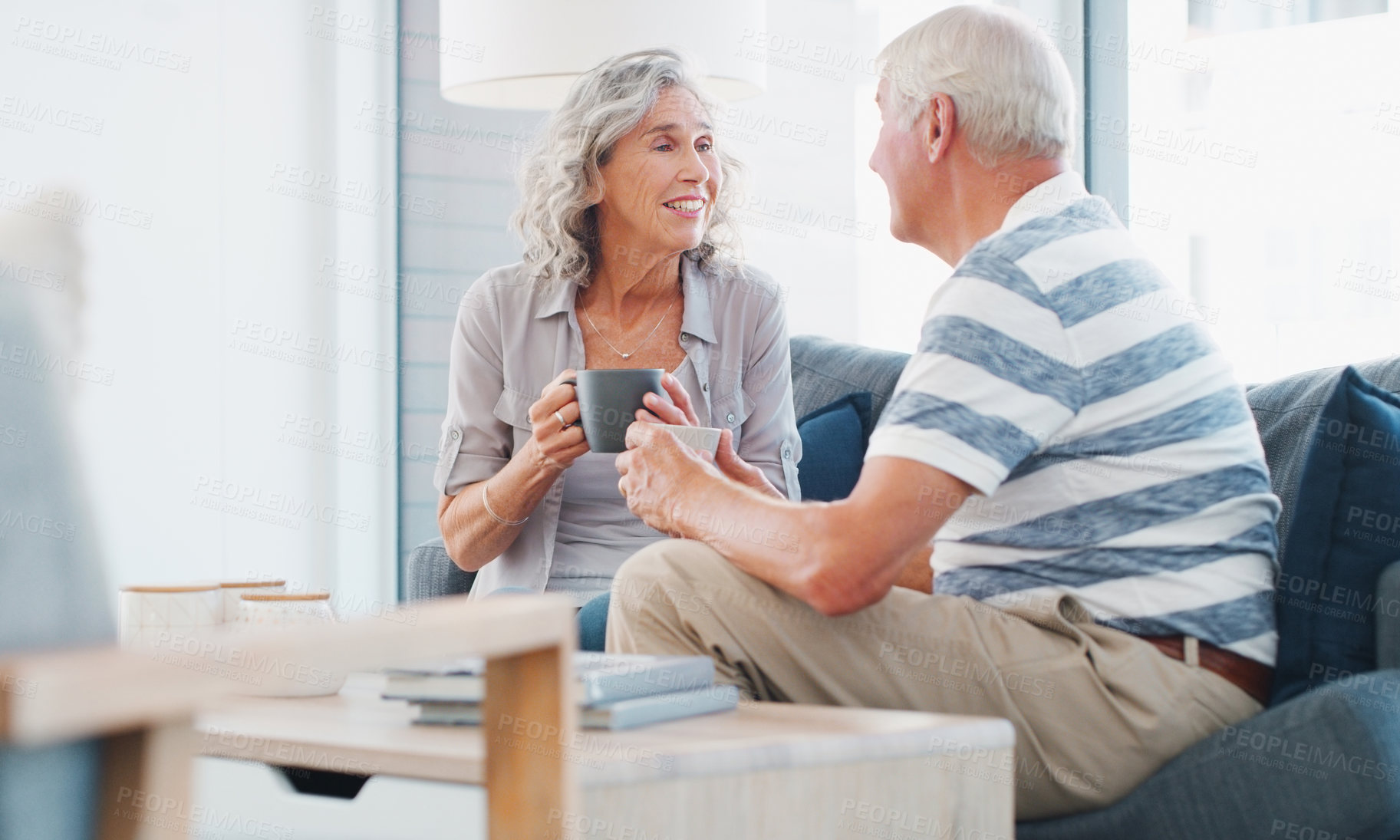 Buy stock photo Mature couple, home and smile with tea on sofa in living room on break, bonding and relax. People, relationship and trust for love with cup for conversation, chat and care for memories on couch