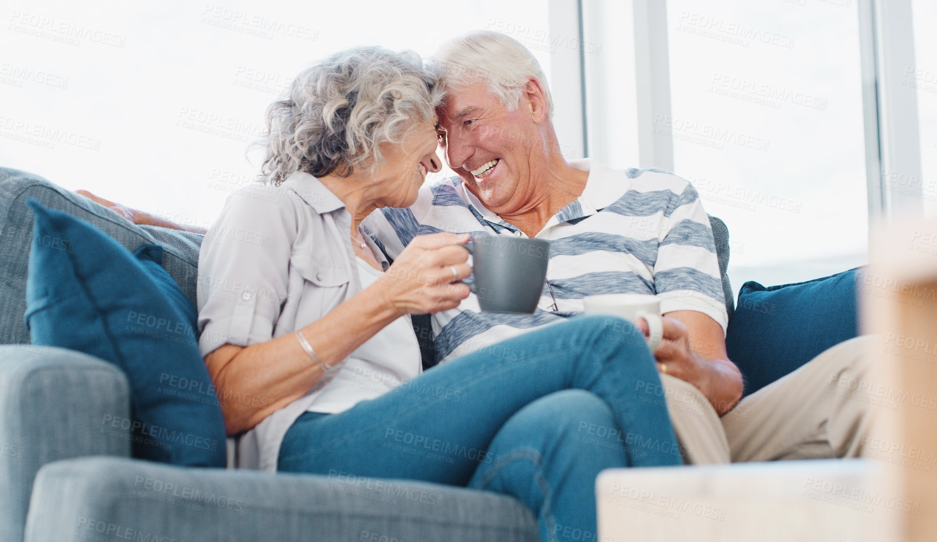 Buy stock photo Shot of a senior couple enjoying a relaxing coffee break on the sofa at home