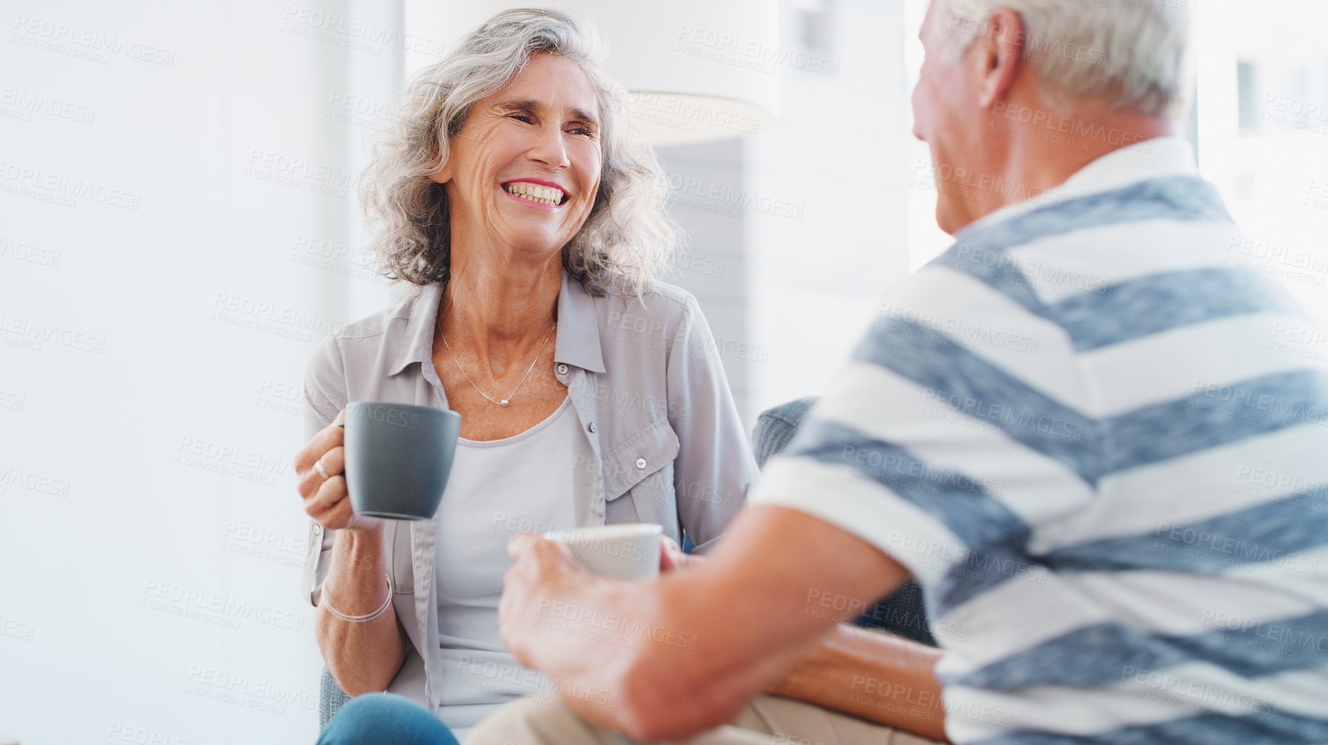 Buy stock photo Shot of a senior couple enjoying a relaxing coffee break on the sofa at home