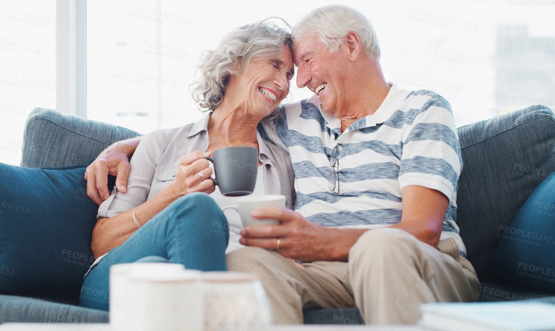 Buy stock photo Shot of a senior couple enjoying a relaxing coffee break on the sofa at home