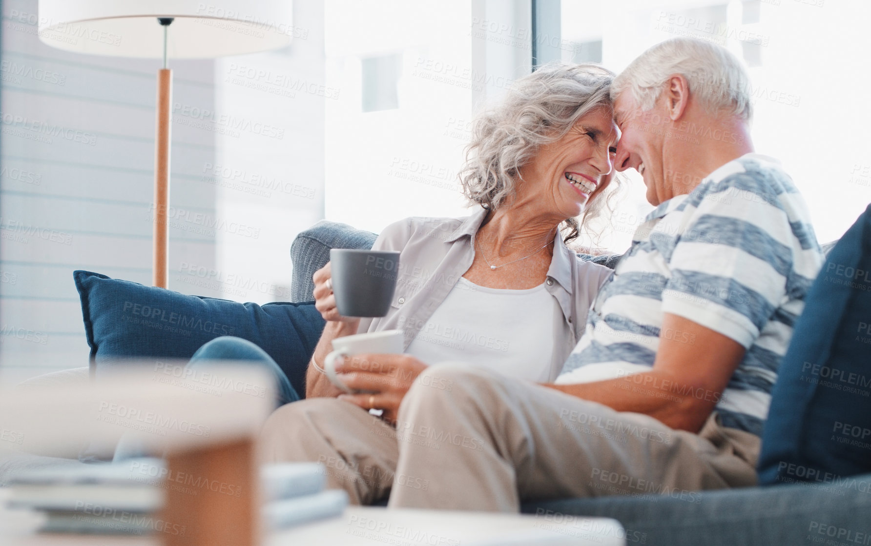 Buy stock photo Shot of a senior couple enjoying a relaxing coffee break on the sofa at home