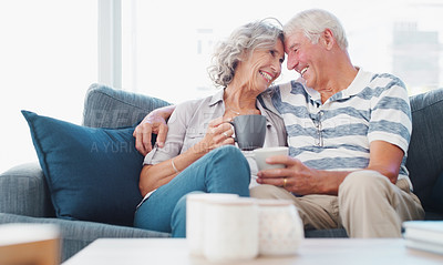 Buy stock photo Shot of a senior couple enjoying a relaxing coffee break on the sofa at home