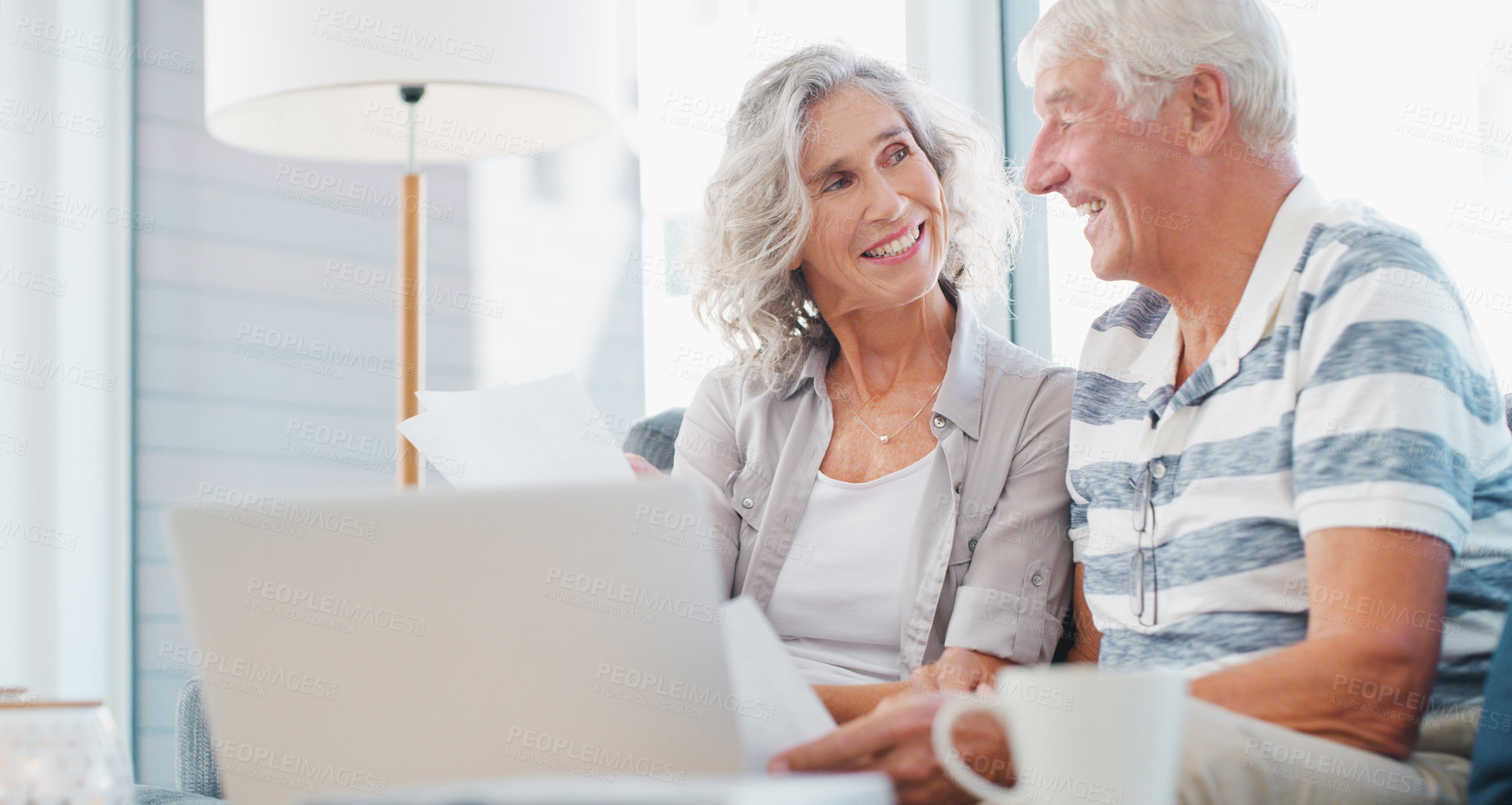 Buy stock photo Shot of a senior couple going through paperwork on the sofa at home