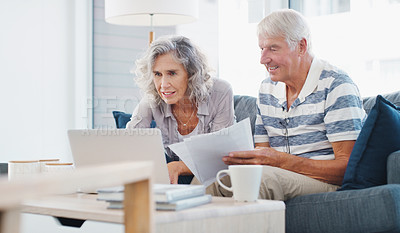 Buy stock photo Shot of a senior couple going through paperwork on the sofa at home