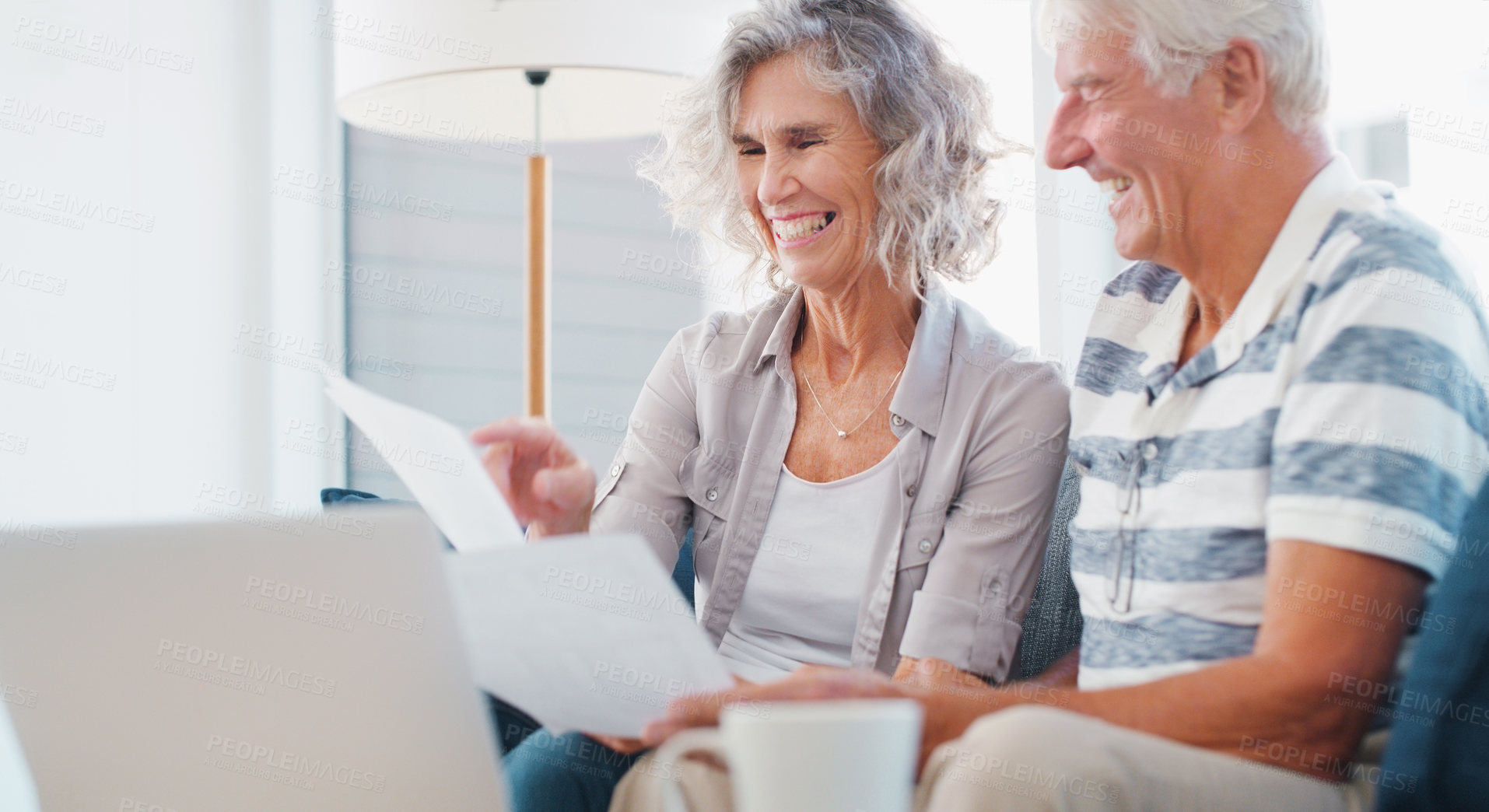 Buy stock photo Shot of a senior couple going through paperwork on the sofa at home