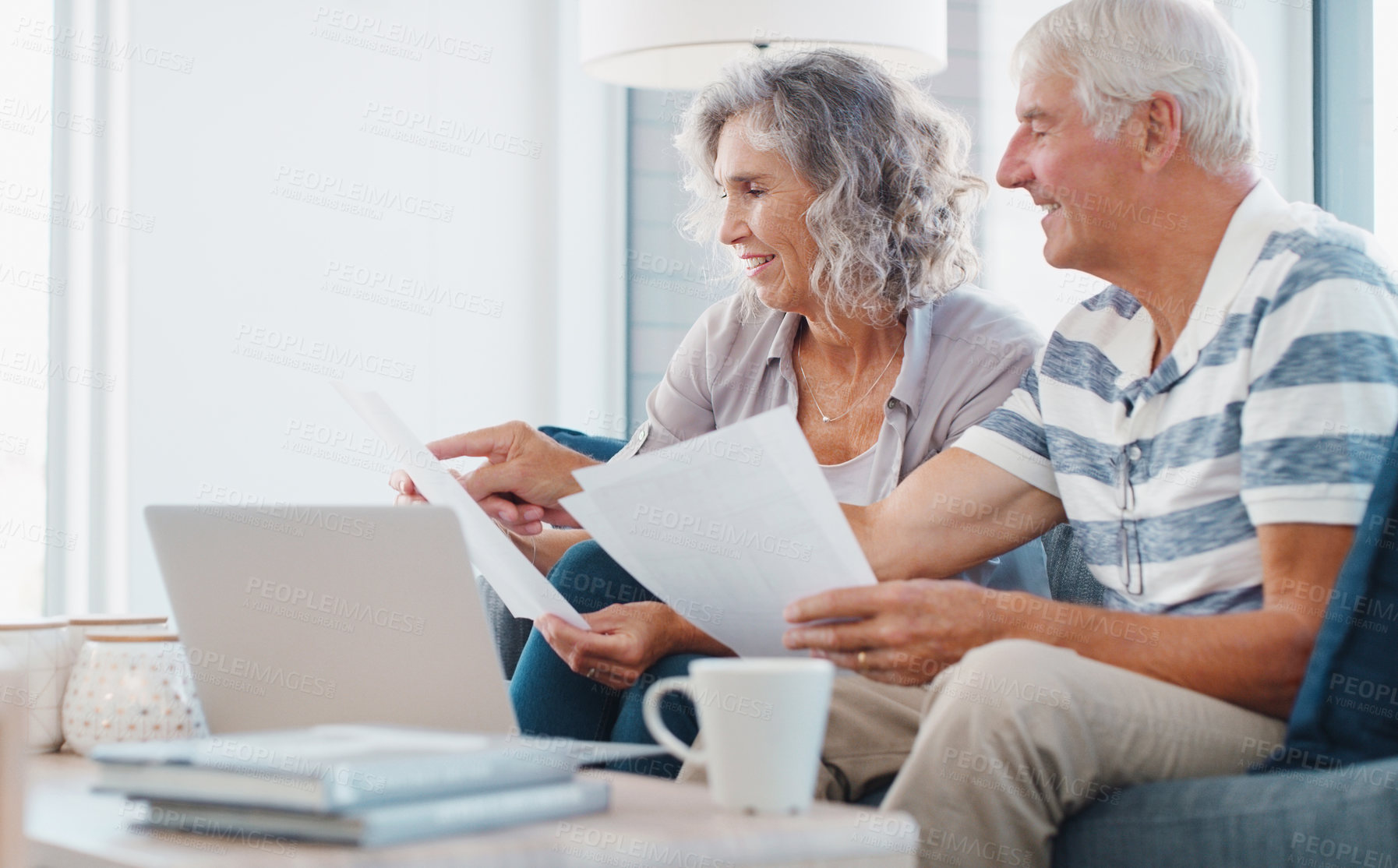 Buy stock photo Shot of a senior couple going through paperwork on the sofa at home