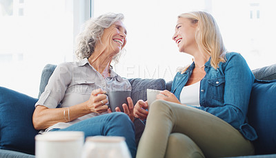 Buy stock photo Shot of a young woman enjoying a coffee break with her mother at home