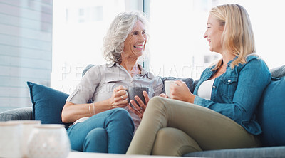 Buy stock photo Shot of a young woman enjoying a coffee break with her mother at home