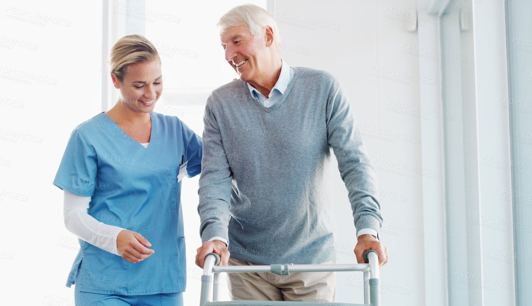 Buy stock photo Shot of a senior man using a walker with the assistance of a young nurse