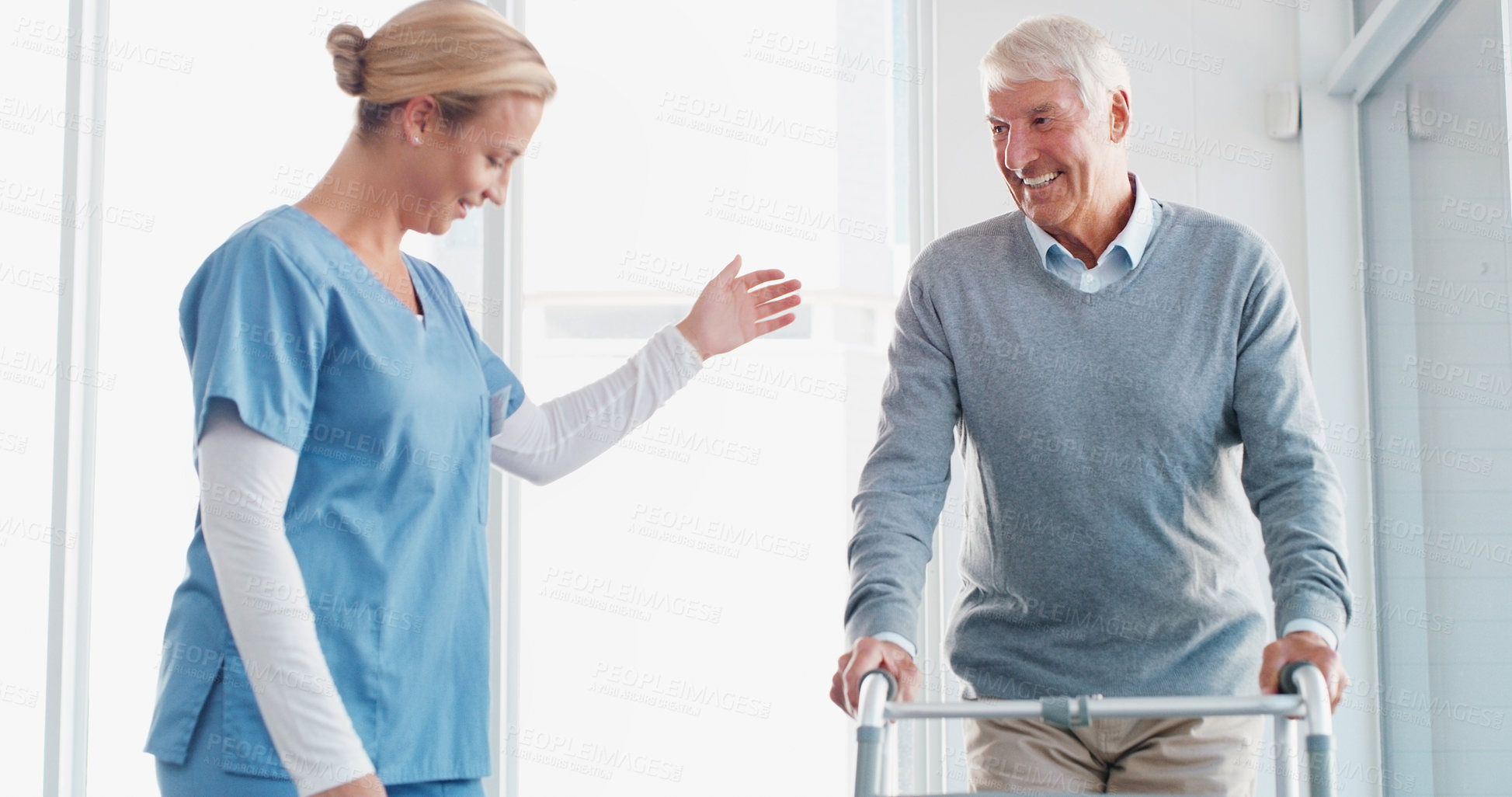 Buy stock photo Shot of a senior man using a walker with the assistance of a young nurse