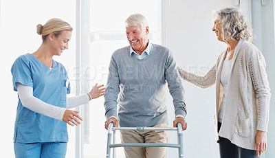 Buy stock photo Shot of a senior man using a walker with the assistance of his wife and young nurse
