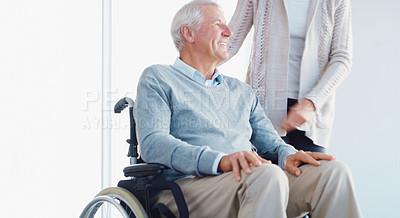 Buy stock photo Shot of a senior man in a wheelchair being cared for by his wife