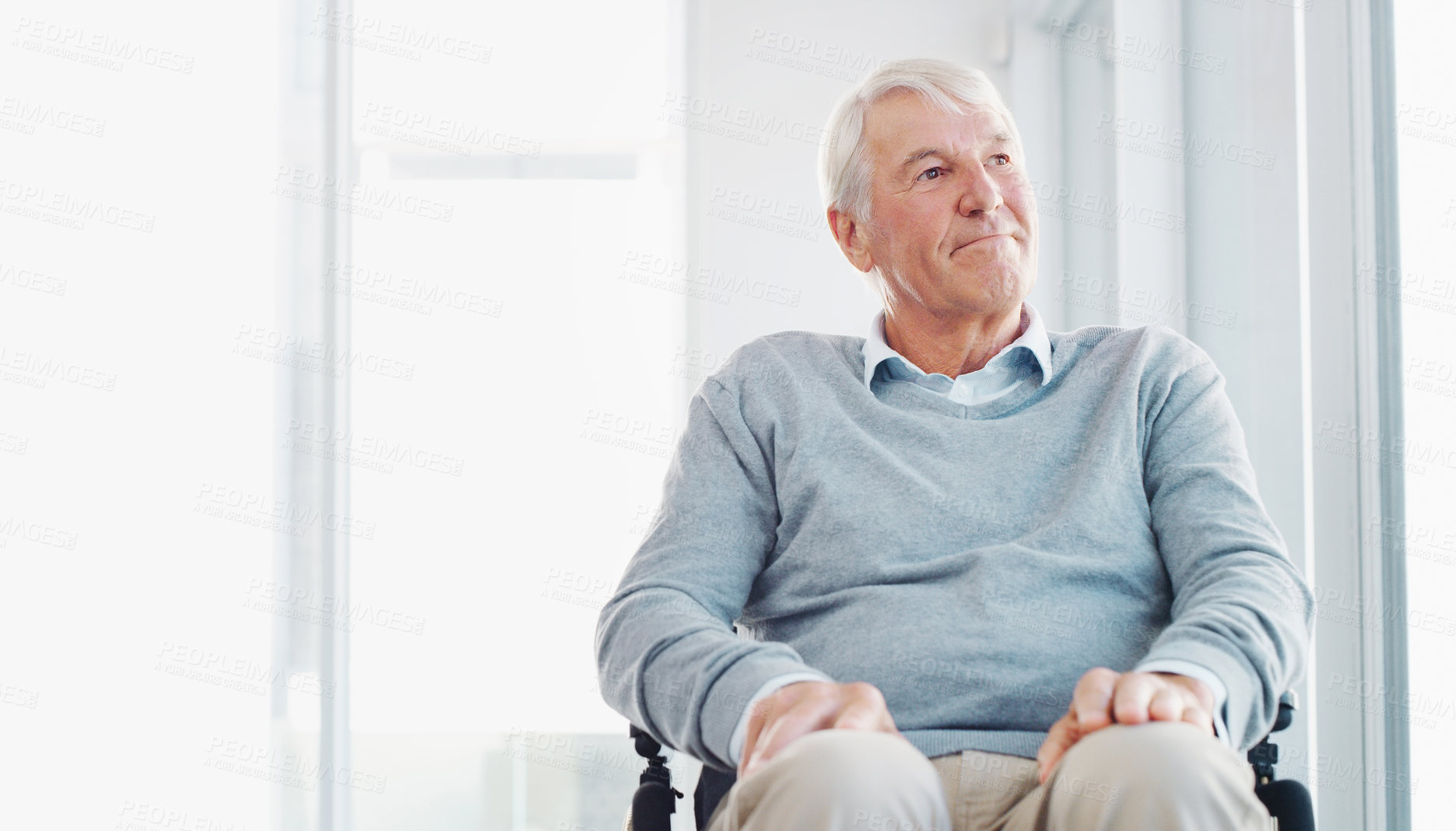 Buy stock photo Shot of a senior man in a wheelchair looking thoughtfully out of a window