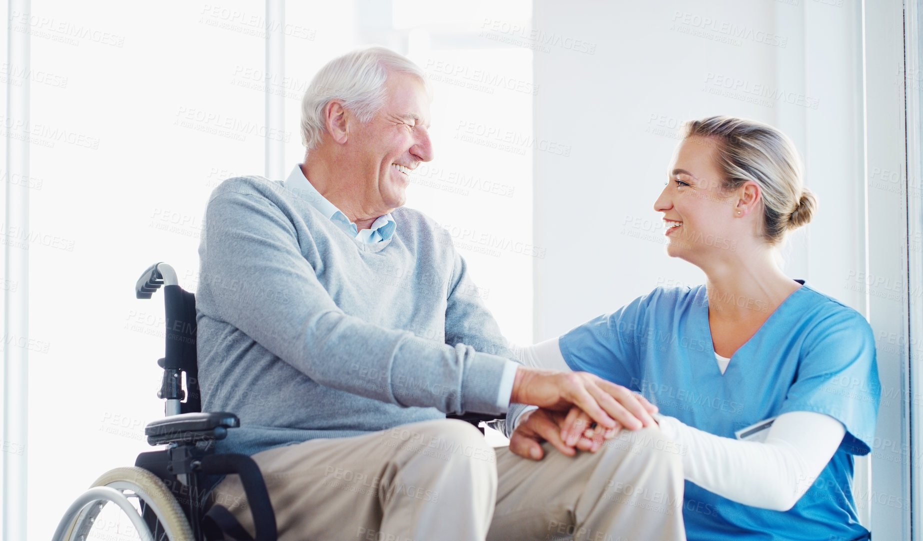 Buy stock photo Caregiver, smile and old man in hospital, holding hands and compassion for senior patient with disability. Clinic, nurse and elderly person on wheelchair, care and support for healthcare and wellness