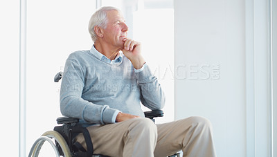 Buy stock photo Shot of a senior man in a wheelchair looking thoughtfully out of a window