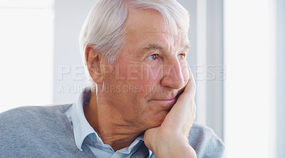 Buy stock photo Shot of a senior man looking thoughtfully out of a window