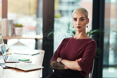 Buy stock photo Cropped portrait of an attractive young businesswoman sitting at her desk in her office with her arms folded