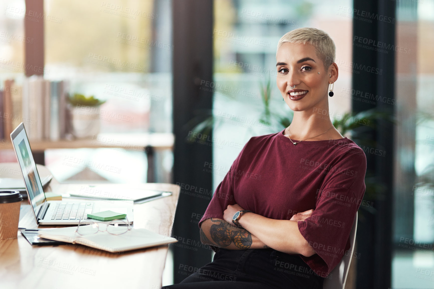 Buy stock photo Cropped portrait of an attractive young businesswoman sitting at her desk in her office with her arms folded