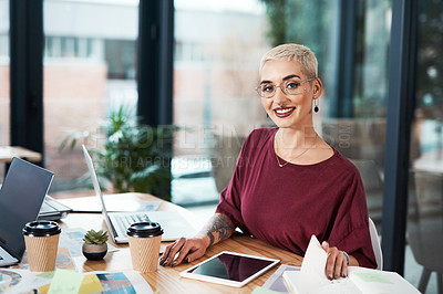 Buy stock photo Cropped portrait of an attractive young businesswoman sitting alone in her office and working with documents and technology