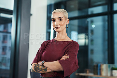 Buy stock photo Cropped portrait of an attractive young businesswoman standing alone in her office with her arms folded