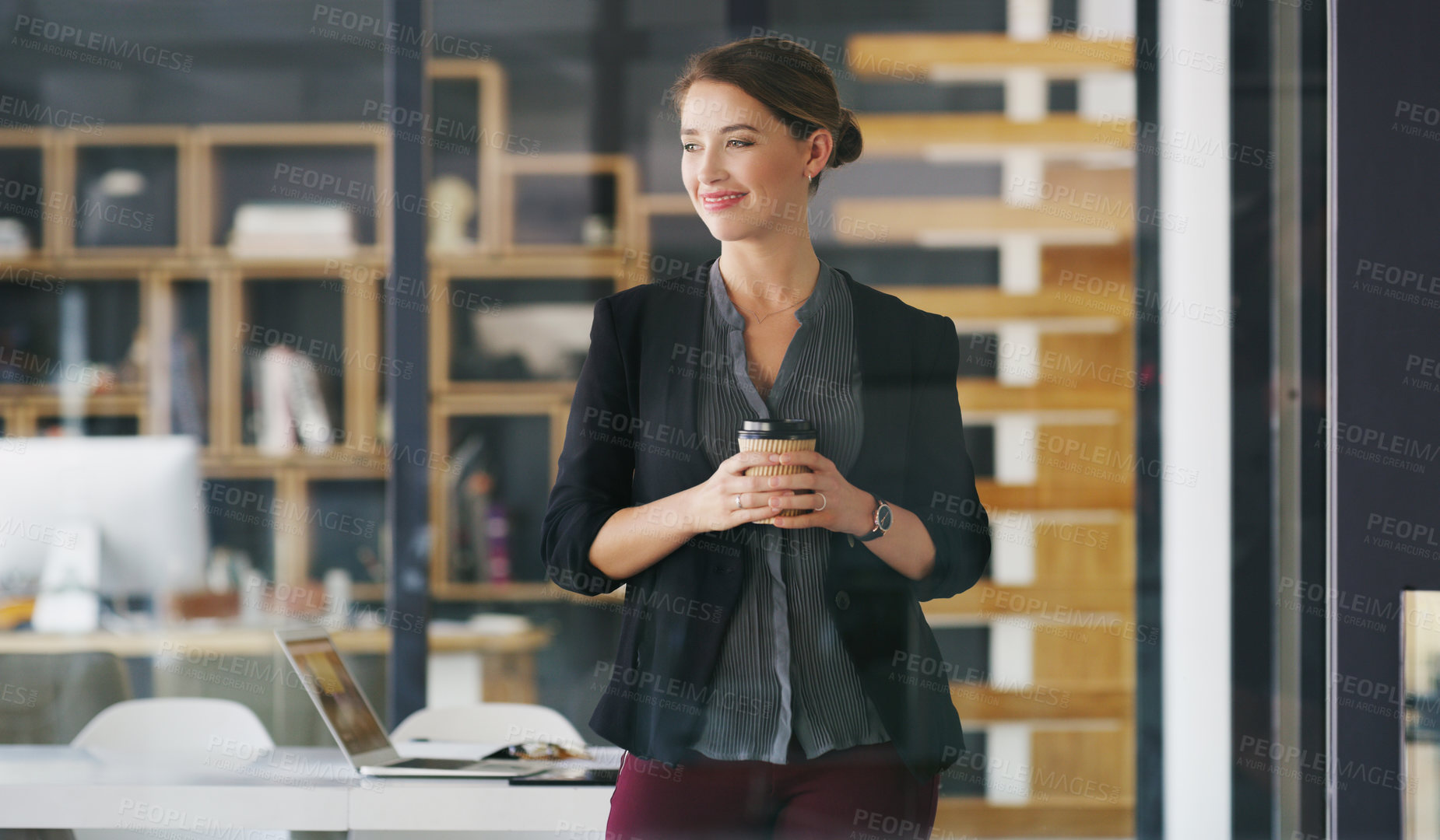 Buy stock photo Cropped shot of an attractive young businesswoman standing alone in her office and holding a cup of coffee