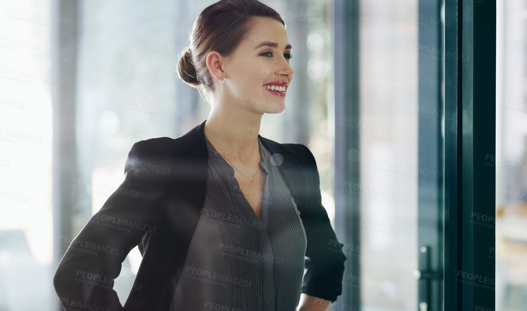 Buy stock photo Cropped shot of an attractive young businesswoman standing alone in her office with her hands on her hips