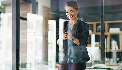Buy stock photo Cropped shot of an attractive young businesswoman standing alone in her office and texting on her cellphone