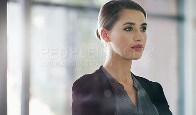 Buy stock photo Cropped headshot of an attractive young businesswoman standing alone in her office and looking contemplative