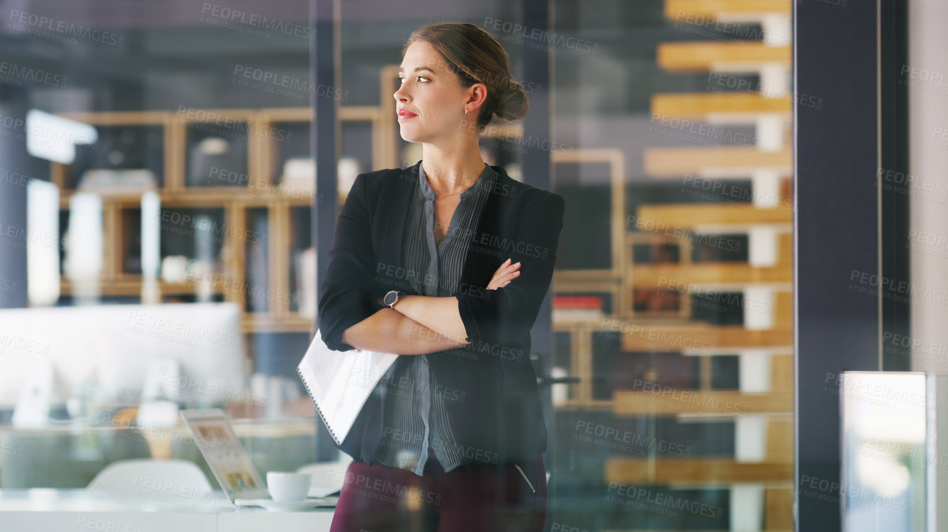 Buy stock photo Cropped shot of an attractive young businesswoman standing alone in her office with her arms folded