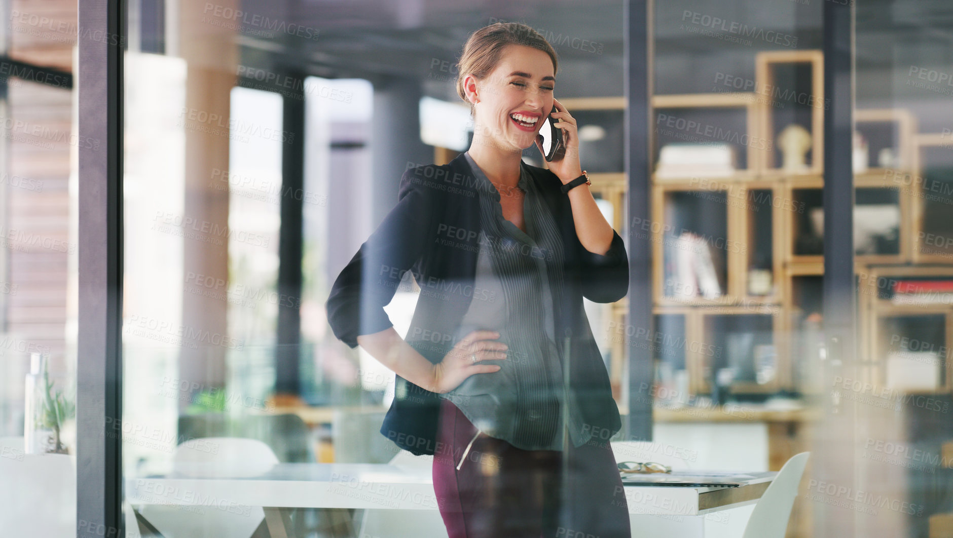 Buy stock photo Cropped shot of an attractive young businesswoman standing alone in her office and talking on her cellphone