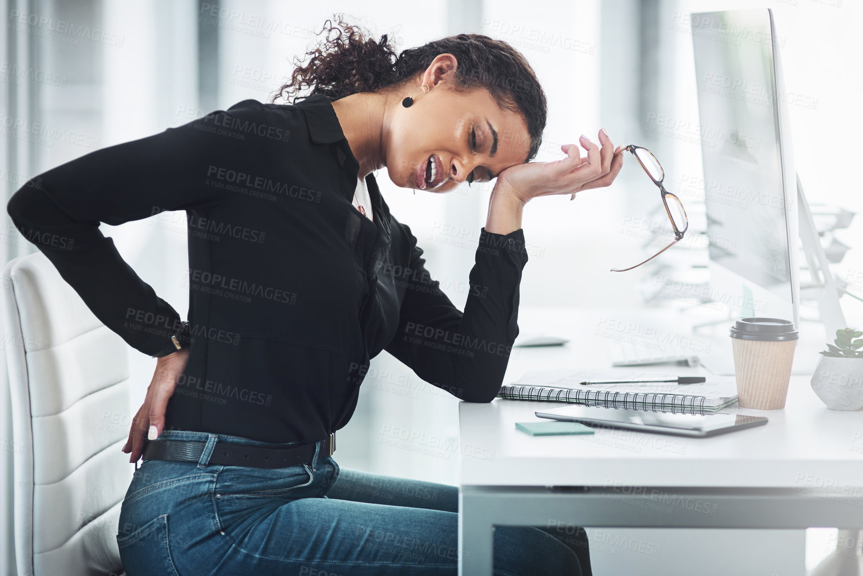 Buy stock photo Shot of a young businesswoman suffering with back ache in an office