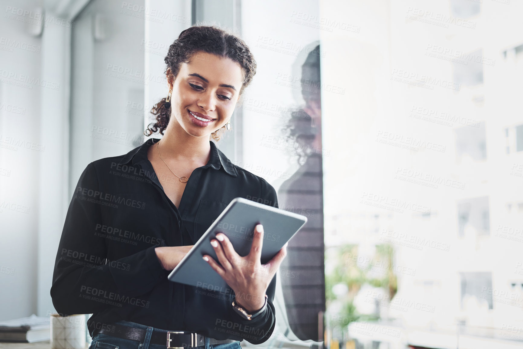 Buy stock photo Shot of a young businesswoman using a digital tablet in an office