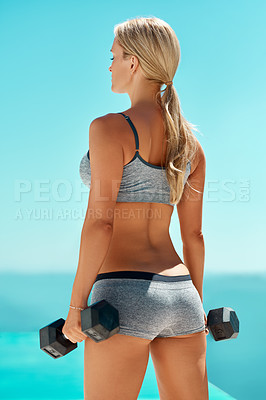 Buy stock photo Rearview shot of a beautiful young woman lifting weights outside