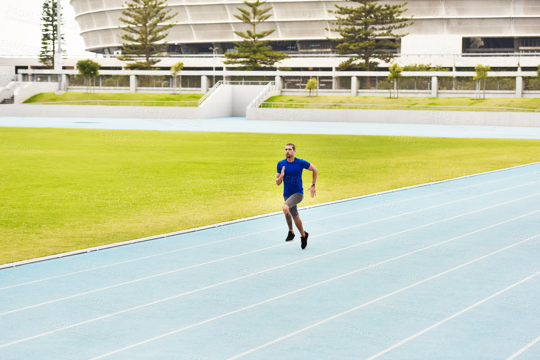 Buy stock photo Fitness, sports man and running on race track for athletics, sprint challenge or competition training in stadium. Runner, exercise and male person for performance, endurance or cardio workout