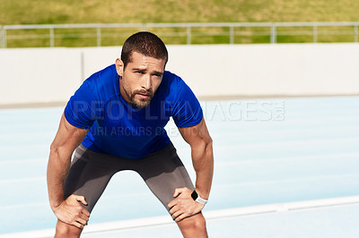 Buy stock photo Cropped portrait of a handsome young male athlete down on his haunches after a workout at the track