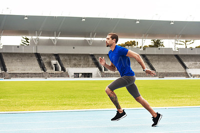 Buy stock photo Full length shot of a handsome young male athlete running along the track