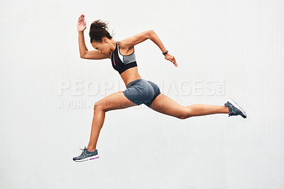 Buy stock photo Full length shot of an attractive young female athlete running along the track