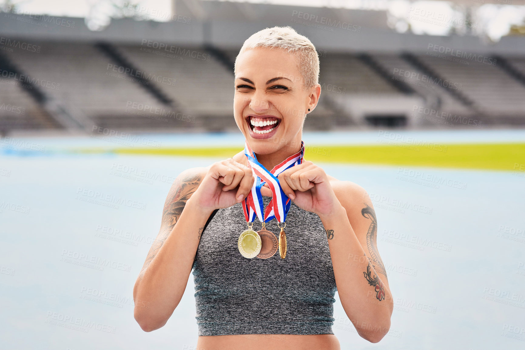 Buy stock photo Portrait, success medals and woman athlete at stadium after winning  race or sports event outdoors. Fitness, winner and female runner happy with victory, goals or target achievement on track field.