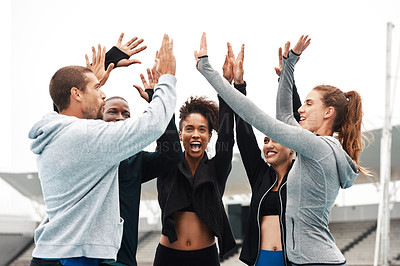 Buy stock photo Cropped shot of a diverse group of athletes standing and giving each other a high five after a track session