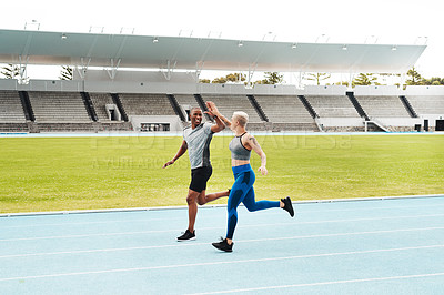 Buy stock photo People, high five and running on track outdoor for exercise, fitness and race in stadium. Male personal trainer, female athlete and diversity in arena for contest, competition and celebration 