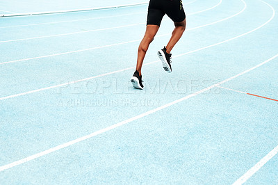 Buy stock photo Cropped shot of an unrecognizable athlete running along a track field alone during an outdoor workout session