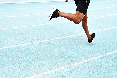 Buy stock photo Cropped shot of an unrecognizable athlete running along a track field alone during an outdoor workout session