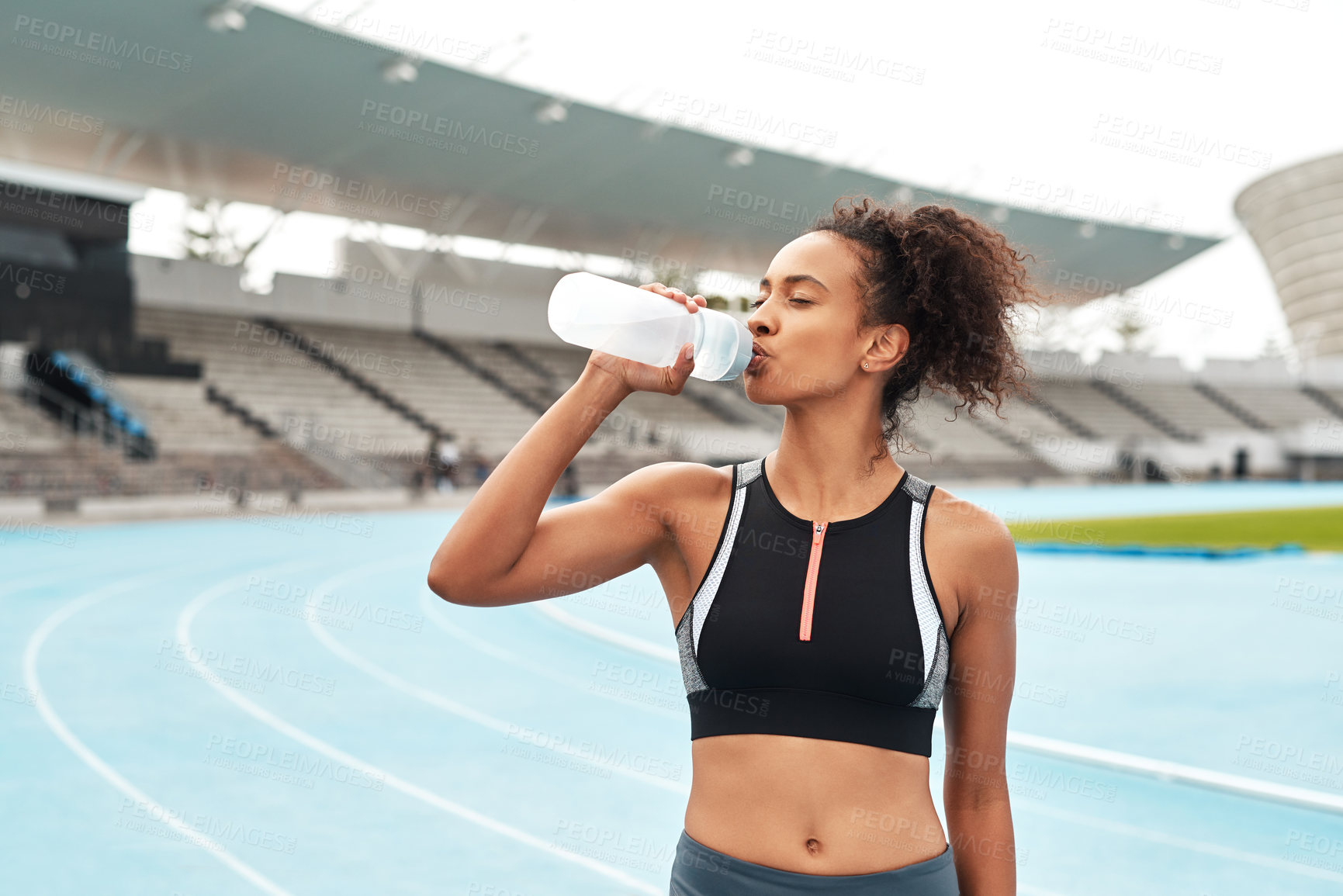 Buy stock photo Fitness, running and woman on track drinking from bottle at stadium, relax during marathon training or exercise. Workout time, health and wellness, healthy female sports runner at area with water.